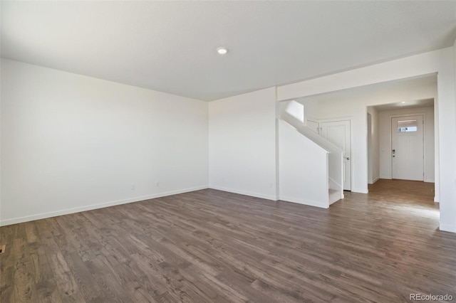 spare room with stairs, dark wood-type flooring, and baseboards