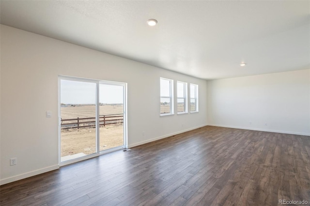 unfurnished room featuring dark wood-type flooring and baseboards