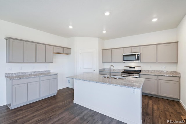 kitchen featuring a sink, appliances with stainless steel finishes, dark wood-style flooring, and gray cabinetry