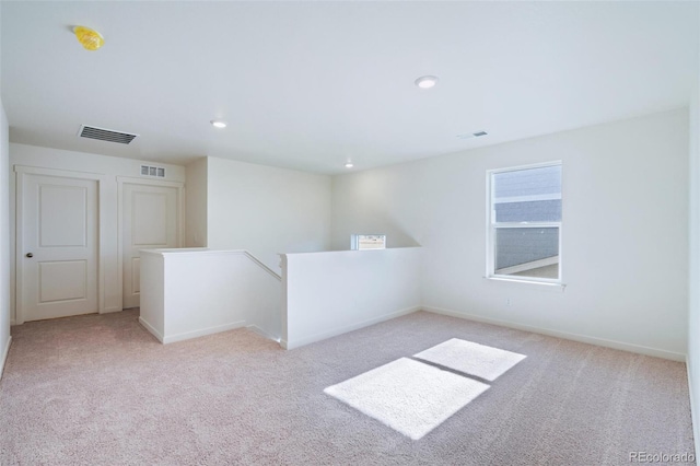 empty room with recessed lighting, light colored carpet, and visible vents