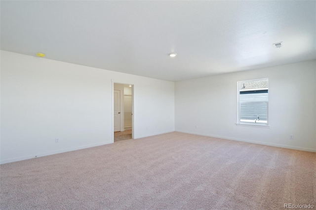 unfurnished room featuring visible vents, baseboards, and light colored carpet