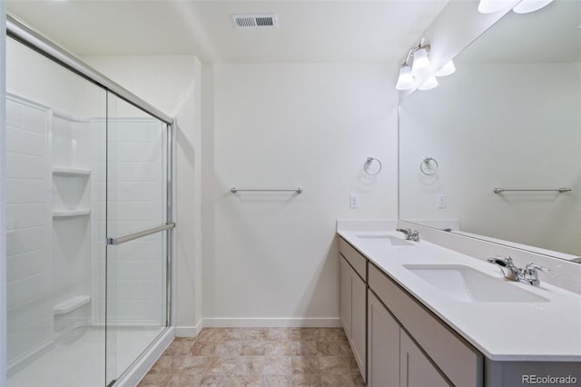 bathroom featuring visible vents, a stall shower, baseboards, and a sink