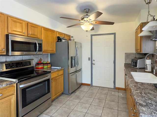 4383 S Eagle Cir, Aurora, CO 80015 - kitchen with stainless steel appliances, tasteful backsplash, a sink, a ceiling fan, and light tile patterned flooring