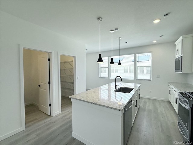 9662 Browns Peak Cir, Littleton, CO 80125 - kitchen with a sink, stainless steel appliances, light wood-style floors, an island with sink, and baseboards