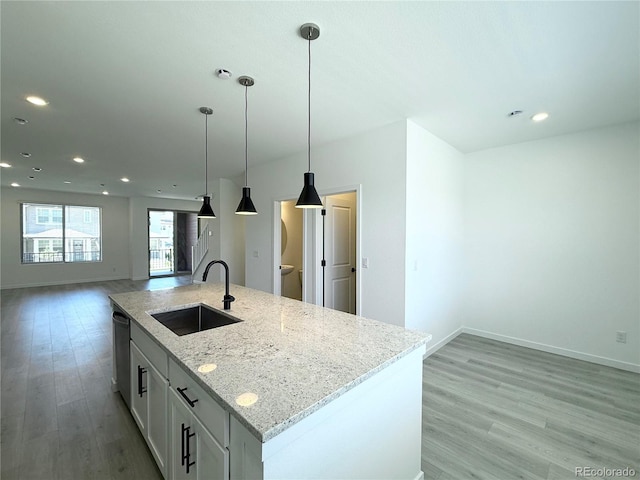 9662 Browns Peak Cir, Littleton, CO 80125 - kitchen featuring a sink, open floor plan, stainless steel dishwasher, light wood-style flooring, and an island with sink