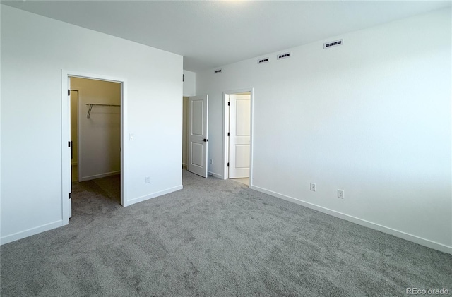 9662 Browns Peak Cir, Littleton, CO 80125 - unfurnished bedroom featuring a walk in closet, carpet flooring, baseboards, and a closet