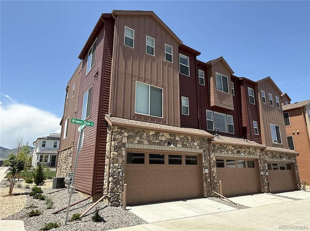 9662 Browns Peak Cir, Littleton, CO 80125 - view of building exterior with an attached garage, cooling unit, driveway, and a residential view