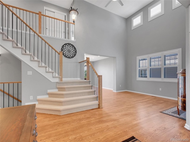 2485 Greensborough Cir, Highlands Ranch, CO 80129 - staircase featuring wood finished floors, a high ceiling, and a ceiling fan