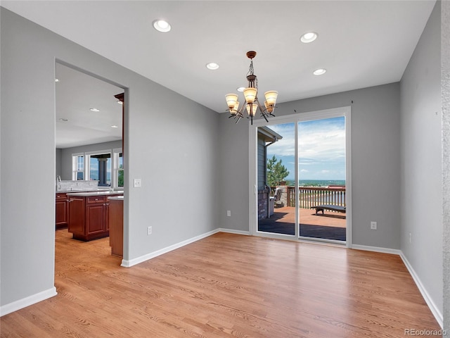 2485 Greensborough Cir, Highlands Ranch, CO 80129 - empty room featuring healthy amount of natural light, a chandelier, light wood-style flooring, and recessed lighting
