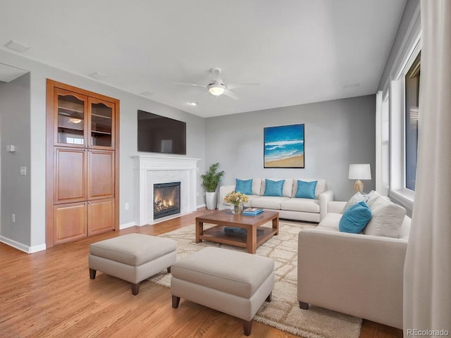 2485 Greensborough Cir, Highlands Ranch, CO 80129 - living room with ceiling fan, light wood-style flooring, and a glass covered fireplace