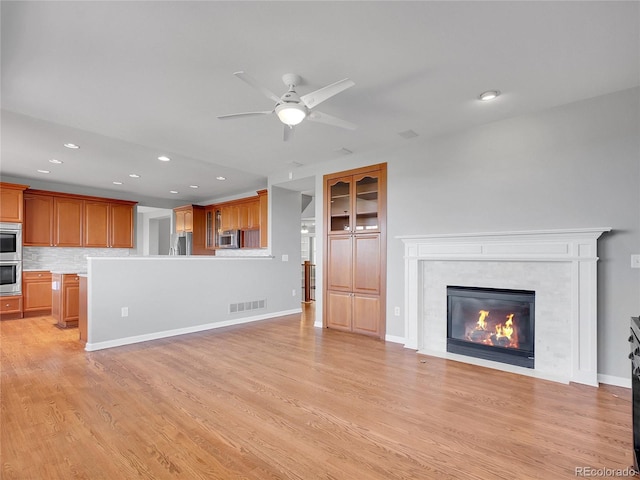 2485 Greensborough Cir, Highlands Ranch, CO 80129 - unfurnished living room featuring recessed lighting, ceiling fan, light wood-style flooring, and a tiled fireplace