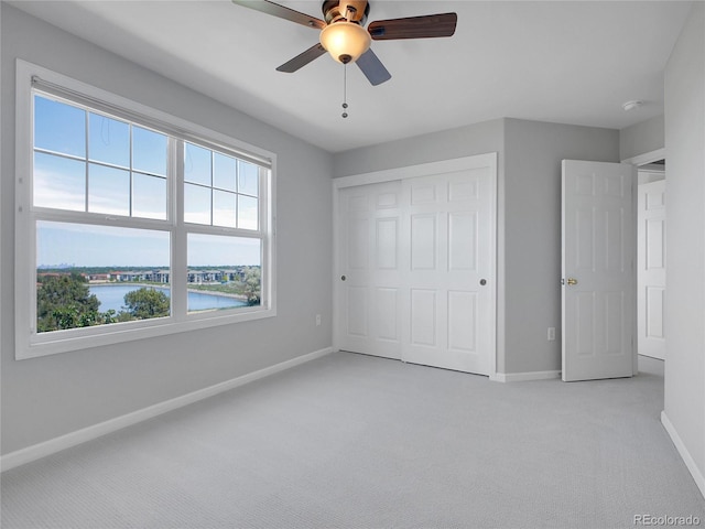 2485 Greensborough Cir, Highlands Ranch, CO 80129 - unfurnished bedroom featuring light carpet, a closet, a water view, and a ceiling fan