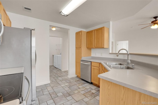 kitchen with independent washer and dryer, appliances with stainless steel finishes, sink, and light brown cabinets