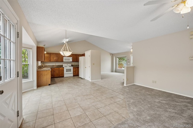 5849 Chokecherry Dr, Colorado Springs, CO 80919 - kitchen featuring brown cabinets, a sink, lofted ceiling, white appliances, and open floor plan