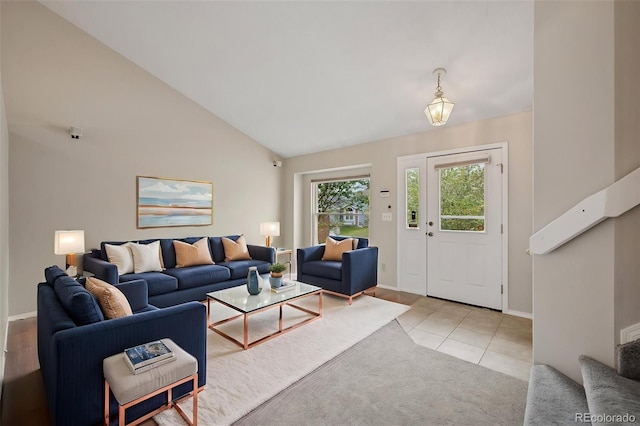 5849 Chokecherry Dr, Colorado Springs, CO 80919 - living area featuring baseboards, high vaulted ceiling, light tile patterned floors, and stairway