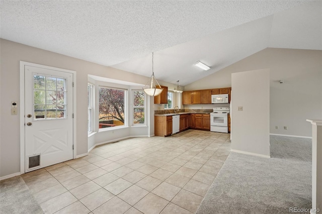 5849 Chokecherry Dr, Colorado Springs, CO 80919 - kitchen featuring brown cabinetry, hanging light fixtures, lofted ceiling, white appliances, and light tile patterned flooring