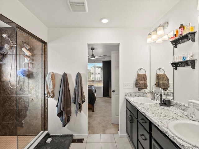 bathroom with tile patterned flooring, vanity, a tile shower, and ceiling fan