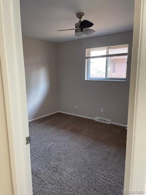 spare room with ceiling fan and baseboards