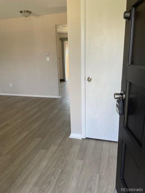 spare room featuring baseboards and light wood-type flooring