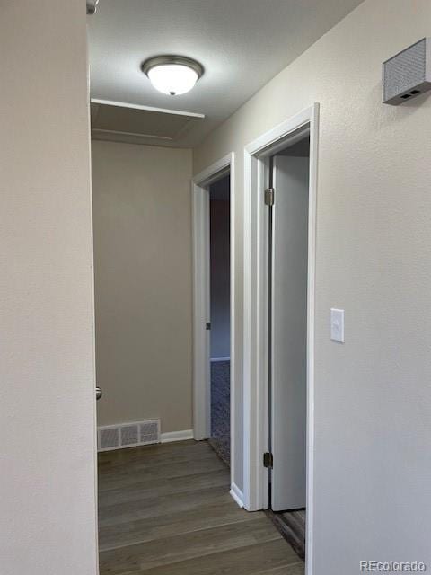 corridor with wood finished floors and baseboards
