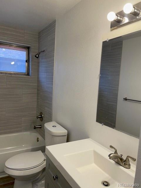 bathroom with toilet, tub / shower combination, and vanity