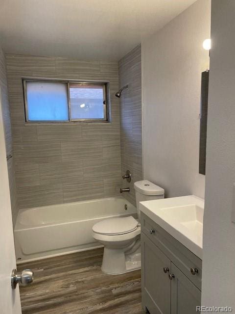 full bathroom featuring wood finished floors, toilet, tub / shower combination, and vanity