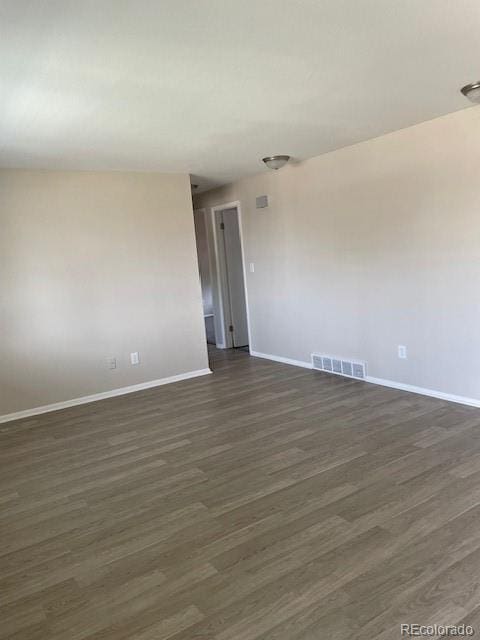 spare room with dark wood-style floors and baseboards