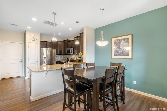 dining area with visible vents, baseboards, and dark wood-type flooring