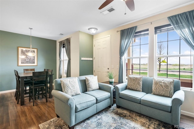 living room featuring baseboards, ceiling fan, wood finished floors, and visible vents