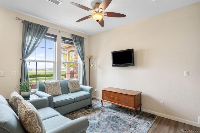 living room featuring baseboards, ceiling fan, visible vents, and wood finished floors