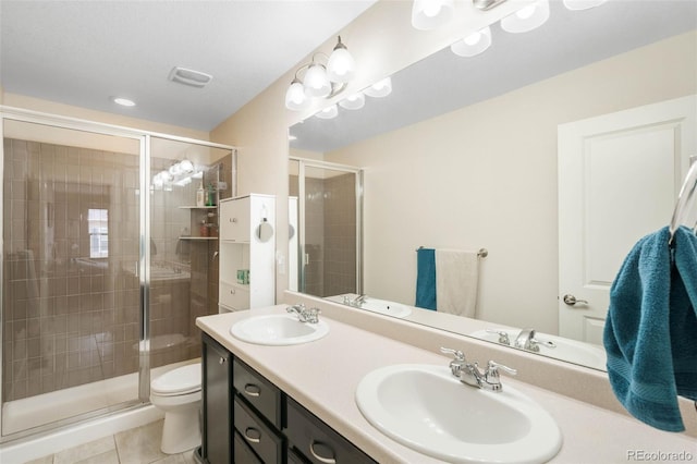 bathroom with a shower stall, a sink, and tile patterned flooring