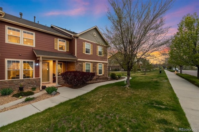view of front of property featuring a yard and stone siding