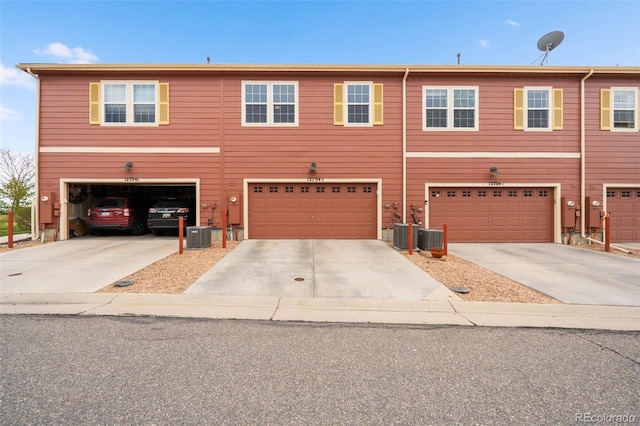 view of front facade with an attached garage, driveway, and central AC