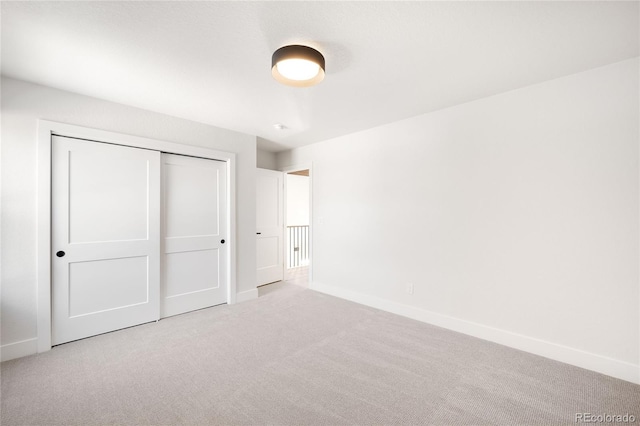 unfurnished bedroom with a closet and light carpet