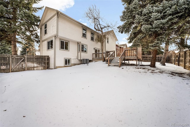 snow covered back of property featuring a wooden deck and central air condition unit