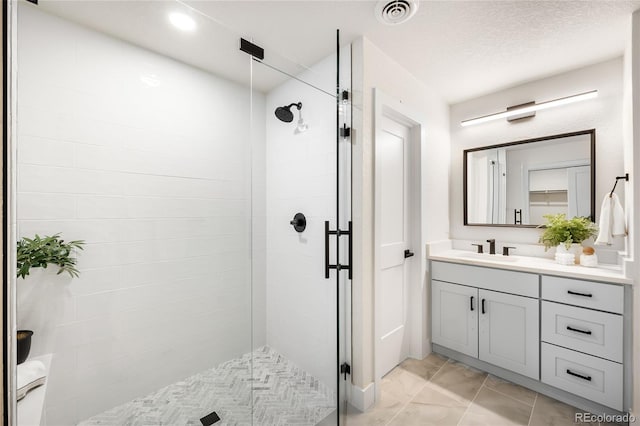 bathroom with vanity, a textured ceiling, and an enclosed shower