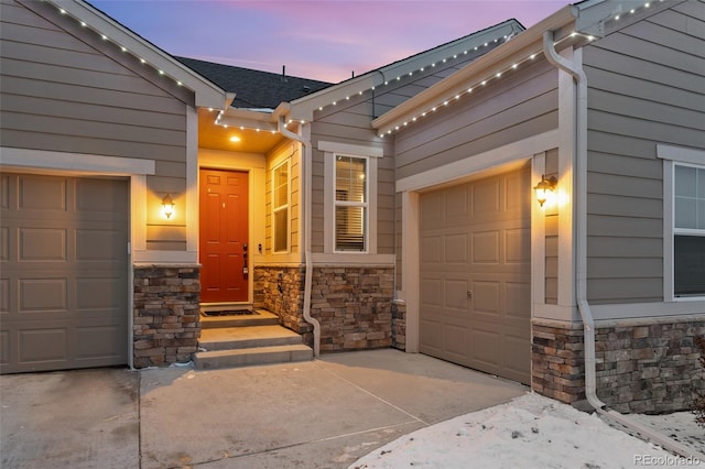 view of front of home featuring a garage, stone siding, and concrete driveway