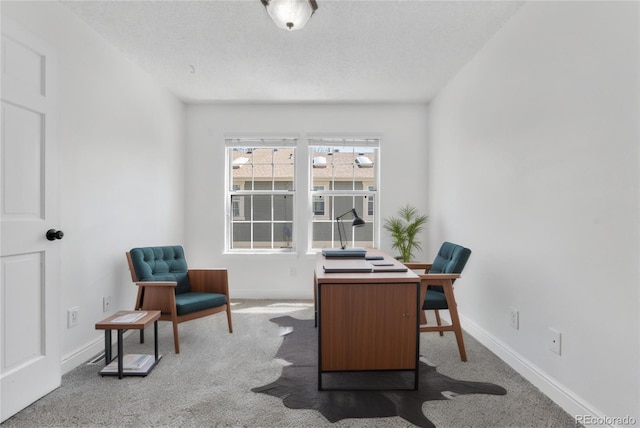 carpeted office with baseboards and a textured ceiling