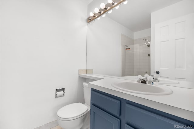bathroom with vanity, toilet, and a tile shower
