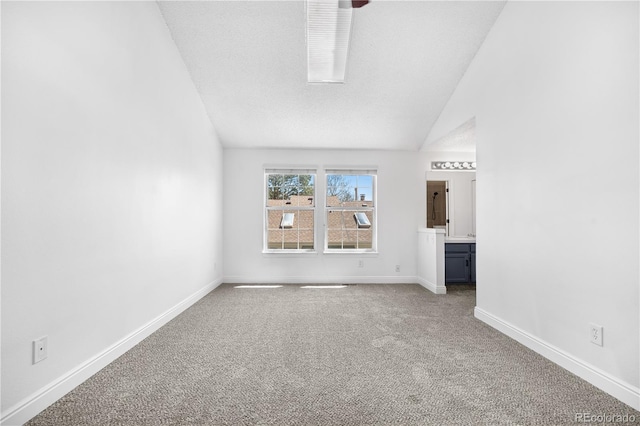 interior space with carpet flooring, baseboards, and lofted ceiling