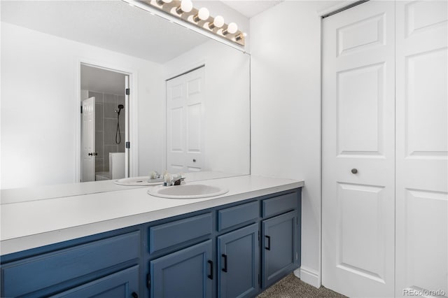 bathroom featuring vanity, a closet, and a tile shower