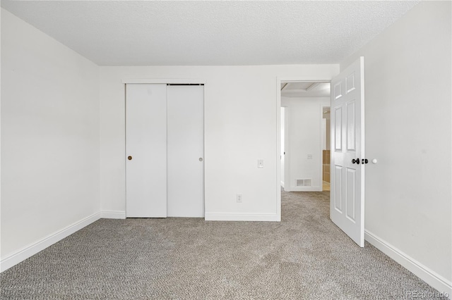 unfurnished bedroom with carpet, a closet, baseboards, and visible vents