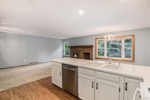 523 E Long Ct, Littleton, CO 80122 - kitchen featuring stainless steel dishwasher, open floor plan, white cabinetry, wood finished floors, and a chandelier