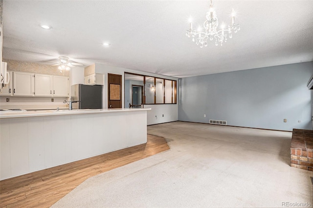 523 E Long Ct, Littleton, CO 80122 - unfurnished living room featuring light wood-style floors, a ceiling fan, a chandelier, and recessed lighting