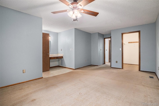 523 E Long Ct, Littleton, CO 80122 - unfurnished bedroom featuring carpet floors, ensuite bath, a walk in closet, a textured ceiling, and ceiling fan