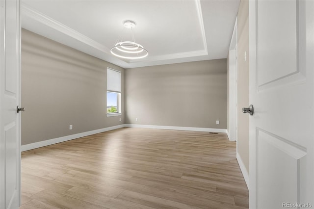 6129 E 143rd Ave, Thornton, CO 80602 - unfurnished room with a tray ceiling and light wood-style flooring