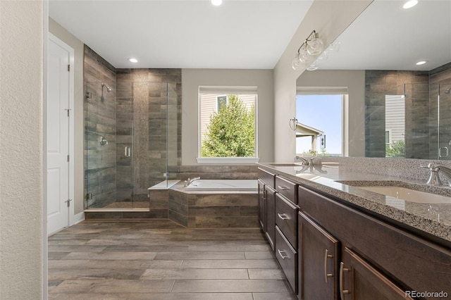6129 E 143rd Ave, Thornton, CO 80602 - full bathroom featuring vanity, a garden tub, a stall shower, wood finished floors, and recessed lighting