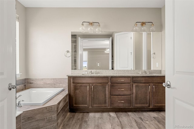 6129 E 143rd Ave, Thornton, CO 80602 - full bathroom with double vanity, a bath, and wood finished floors