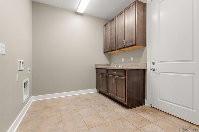 6129 E 143rd Ave, Thornton, CO 80602 - washroom featuring cabinet space, electric dryer hookup, and light tile patterned floors