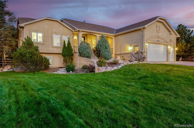 view of front facade with a yard and a garage